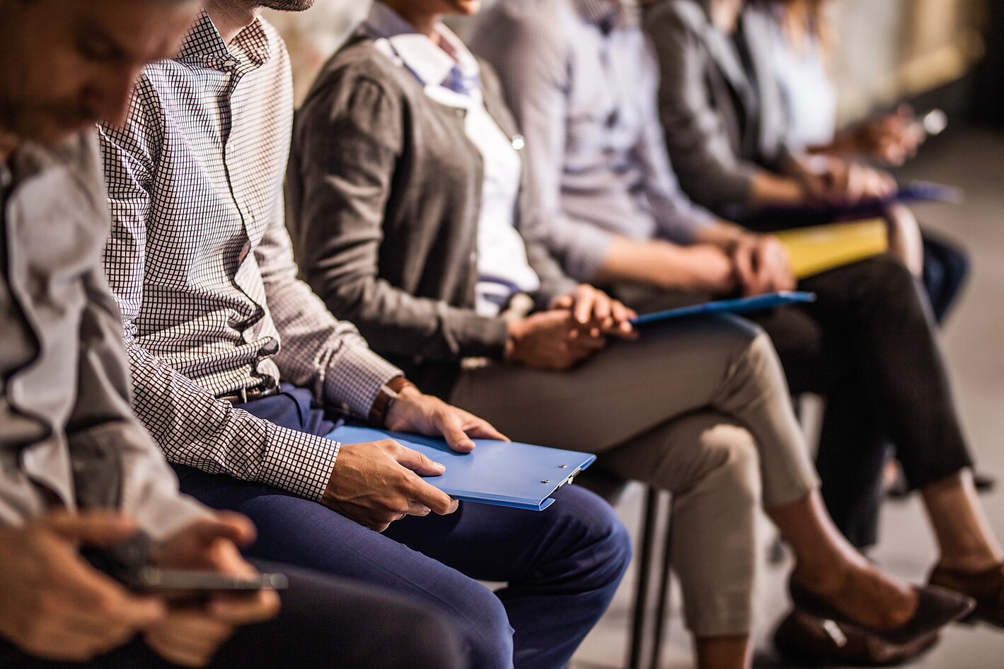 Professionals seated with folders on their laps waiting