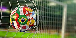 Football ball with flags of world countries in the net of goal of football stadium. 