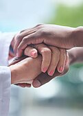 Doctor holding hands with patient.